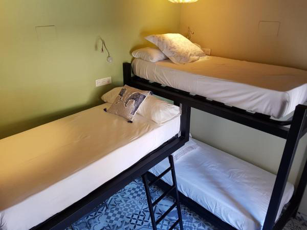 Cama en habitación compartida mixta con 5 camas y baño 
